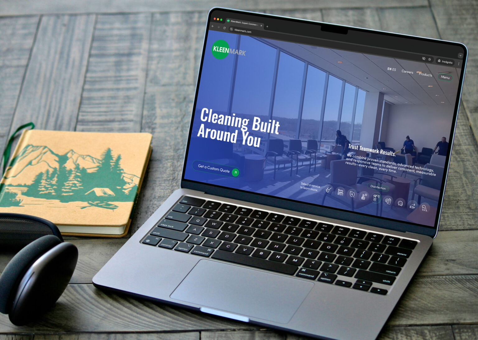 KleenMark website redesign hero section displayed on a laptop mockup with office accessories.